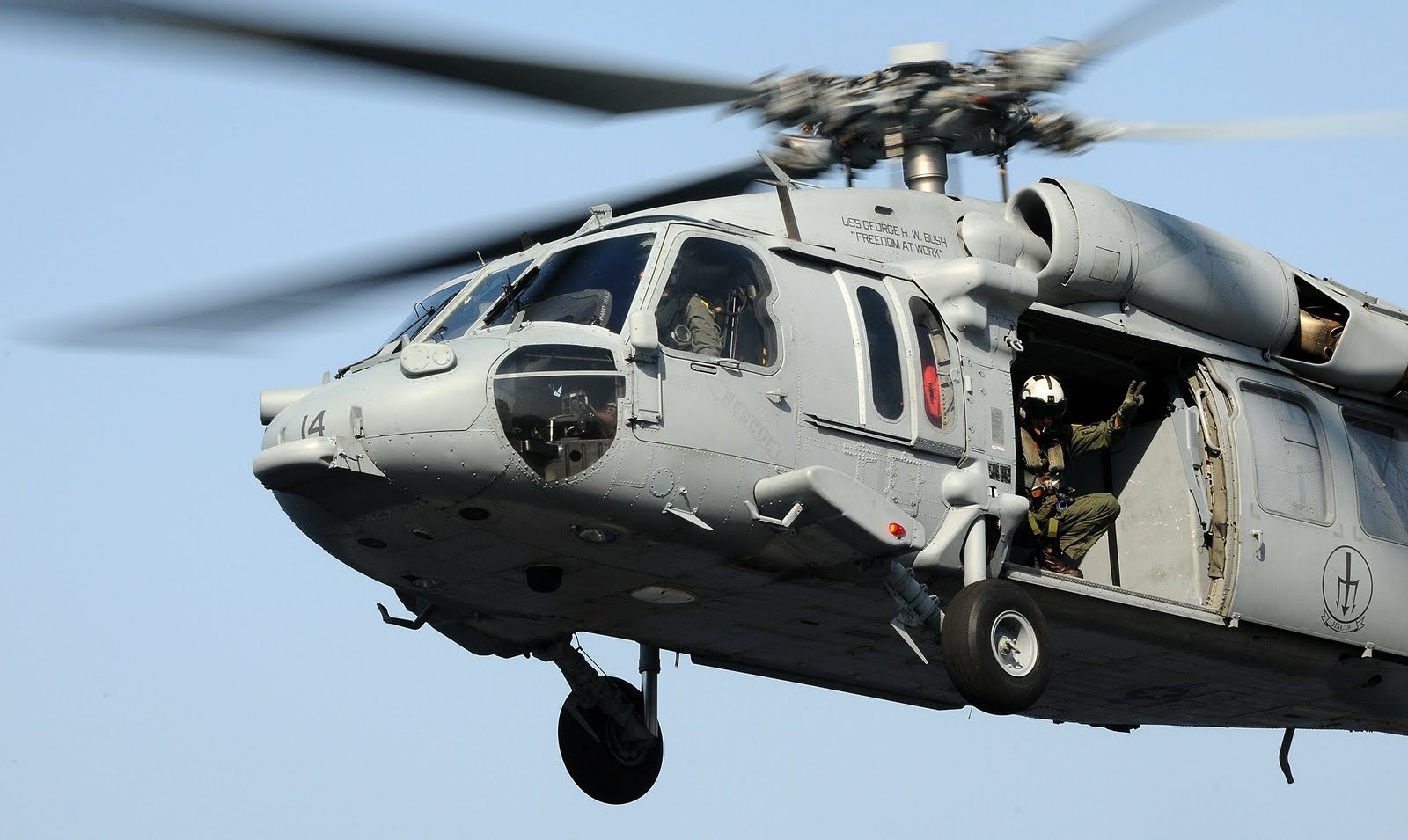 A Sikorsky SH-60 Seahawk military helicopter in flight, used by the navy for various tactical and transport missions.