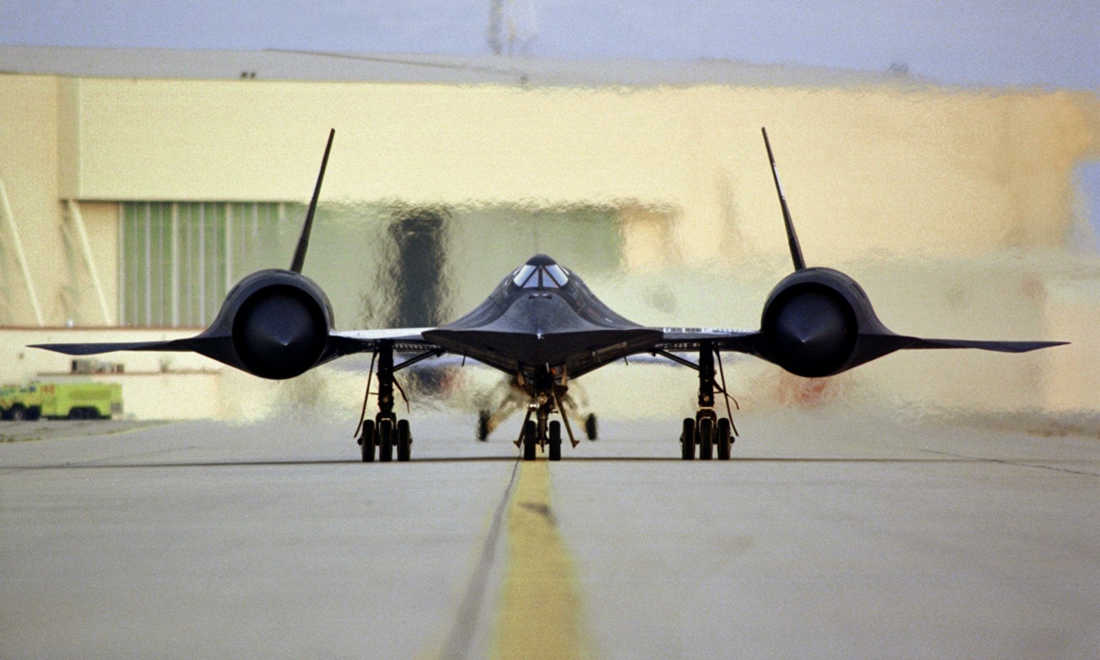 Military Lockheed SR-71 Blackbird aircraft is shown from the front on a runway, showcasing its sleek, aerodynamic design and distinctive twin-engine nacelles.