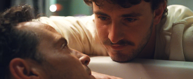 Intense scene from All of Us Are Strangers movie featuring two characters in a close confrontation.