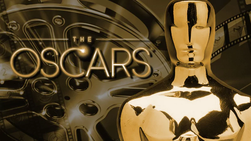 Close-up of an Oscar statuette with the text The Oscars and film reels in the background, symbolizing the Academy Awards celebration.