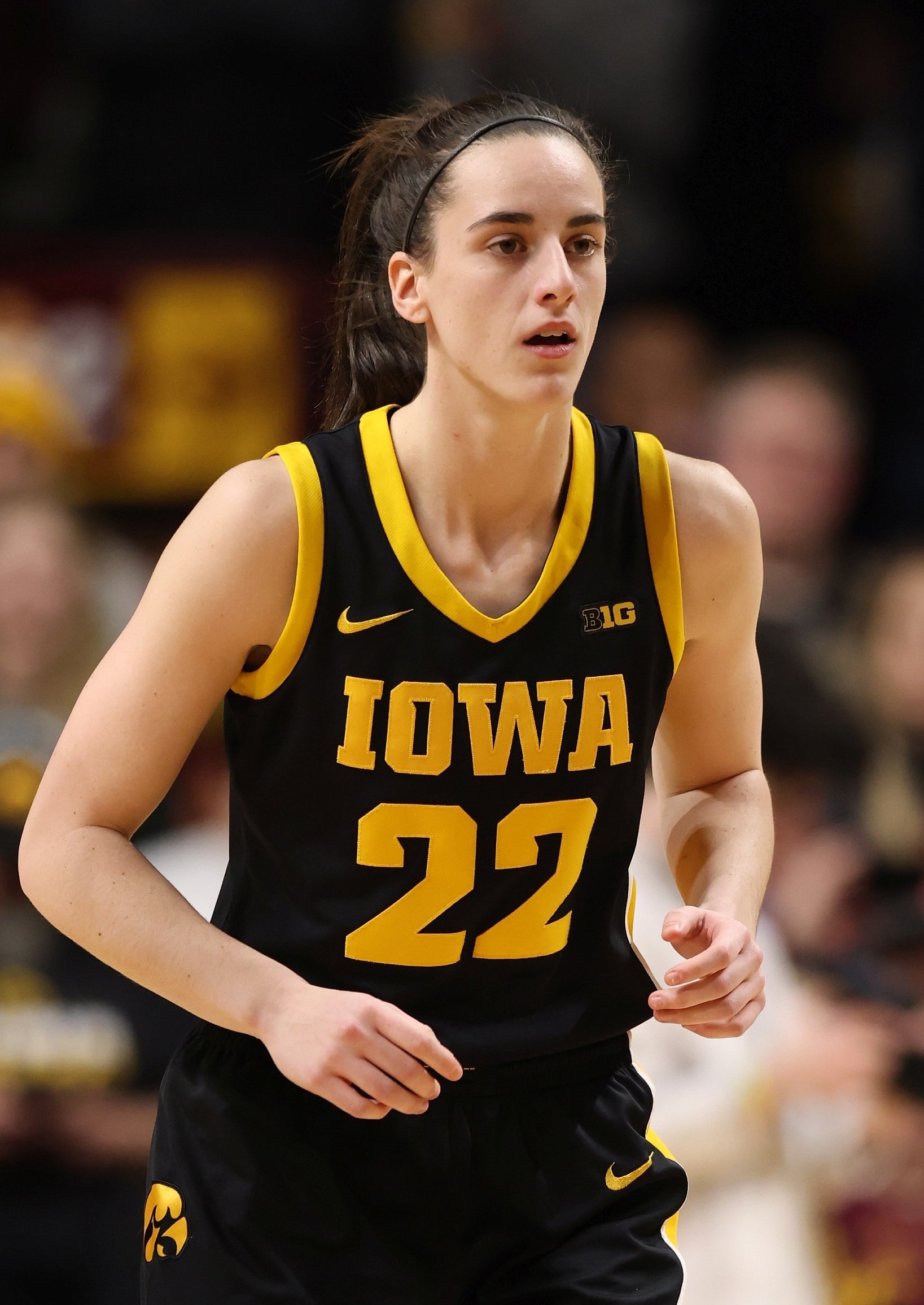 A basketball player in an Iowa jersey number 22 is focused during a game.