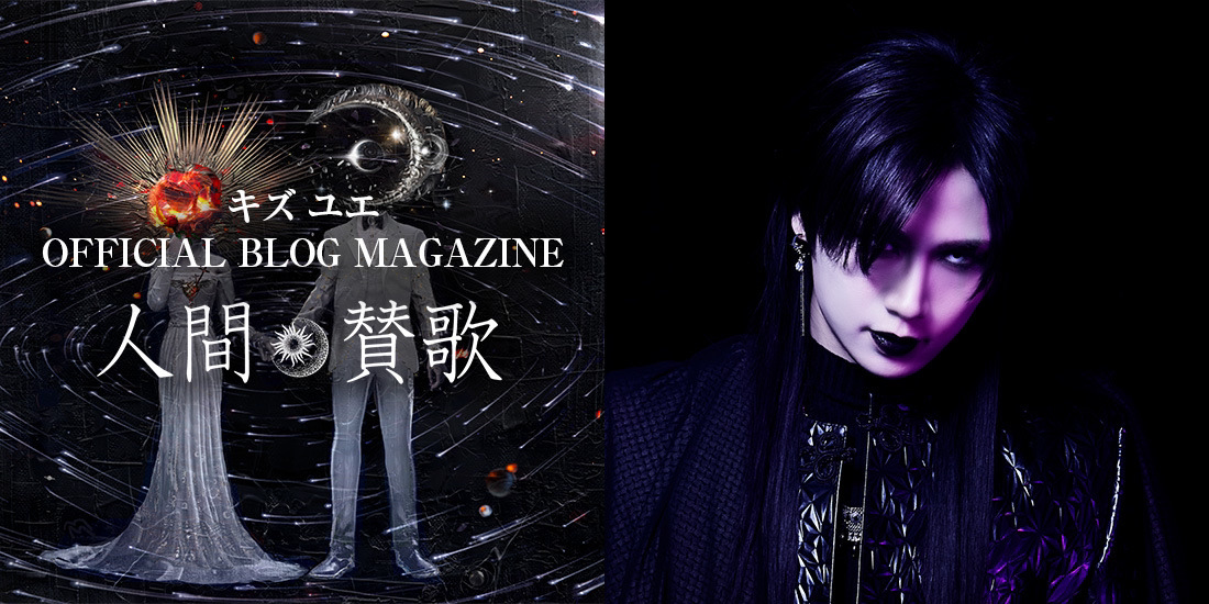Dark-haired Japanese visual kei artist Kizu with intricate makeup, sporting edgy style, on a vibrant stage. A blend of Vkei and JRock fashion and flair.