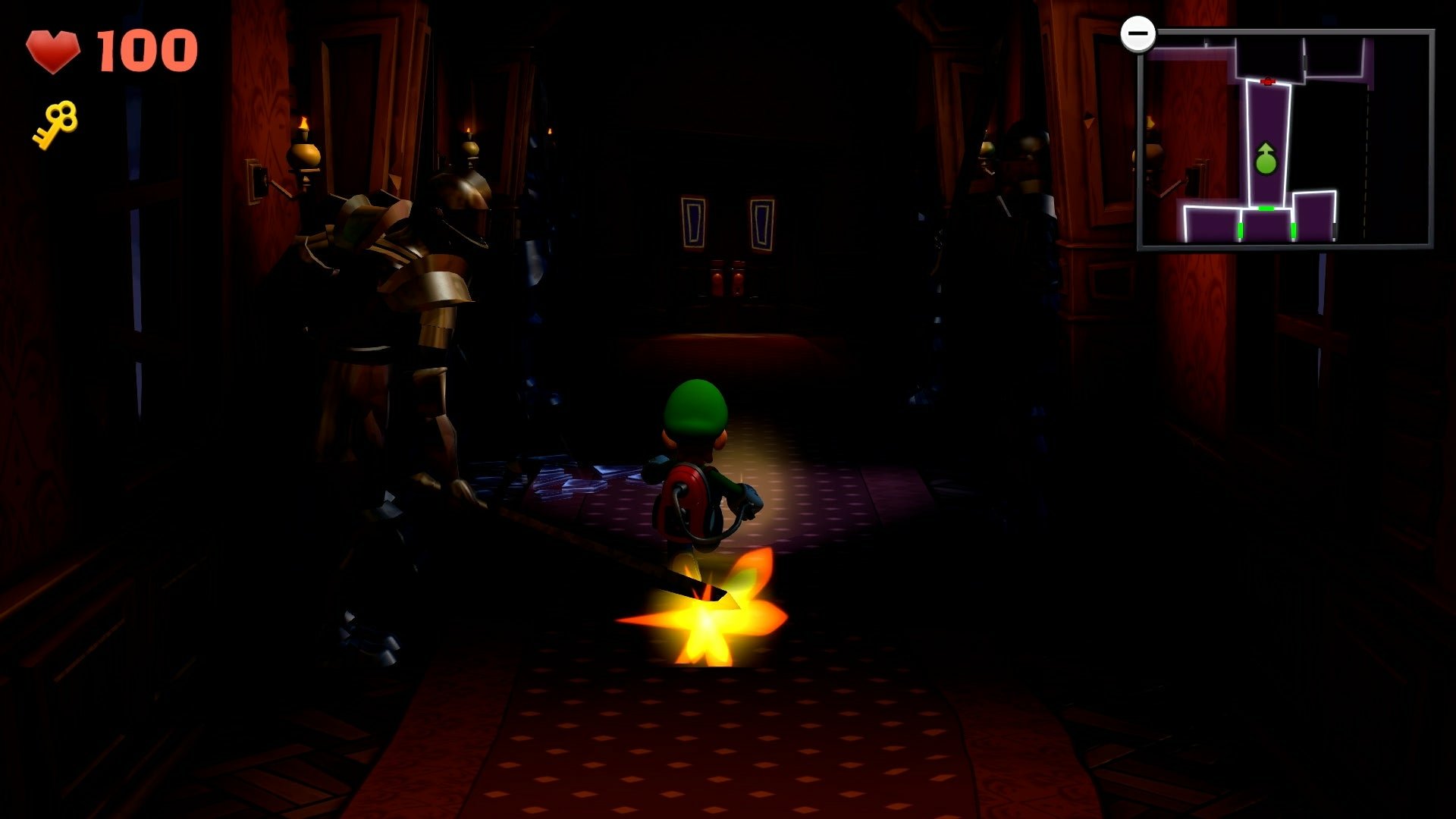 Luigi explores a dark hallway with armored suits, carrying a flashlight in a scene from the video game Luigi's Mansion 2. A mini-map and health status are visible in the top corners.