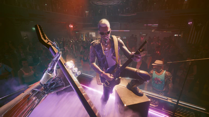 A character in Cyberpunk 2077 performs live on stage with a futuristic guitar, surrounded by neon lights and a crowd in a vibrant cyberpunk setting.