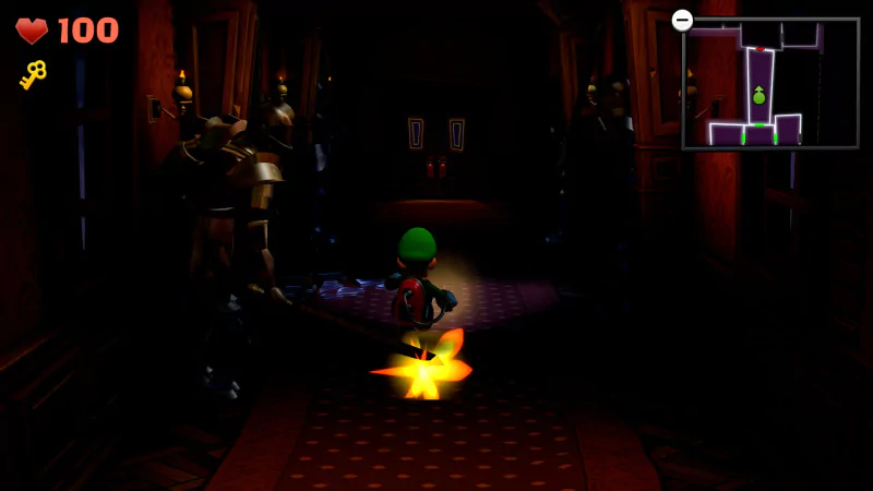 Luigi explores a dark hallway with armored suits, carrying a flashlight in a scene from the video game Luigi's Mansion 2. A mini-map and health status are visible in the top corners.