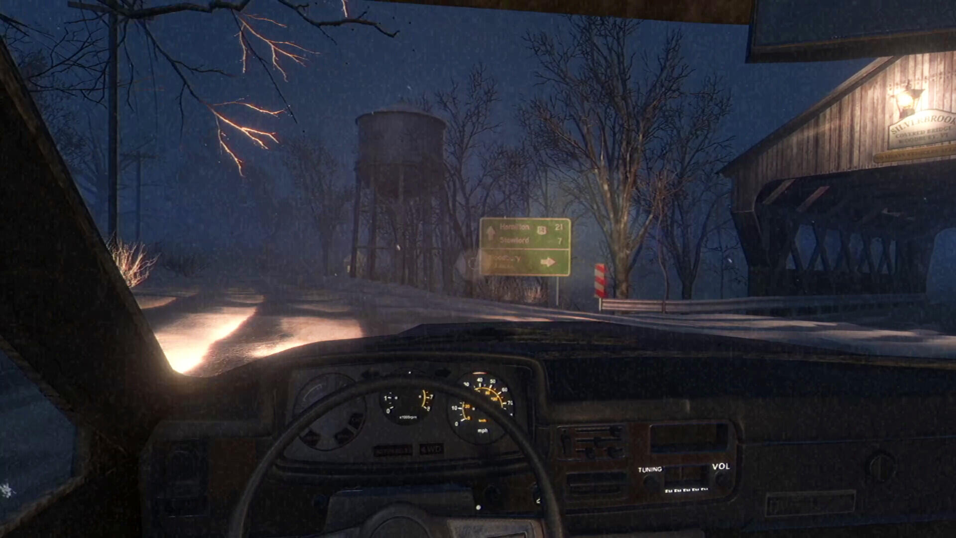 The image shows a nighttime scene from the video game Fears to Fathom - Woodbury Getaway, featuring a car interior with a dark landscape, a water tower, and faintly lit sign.