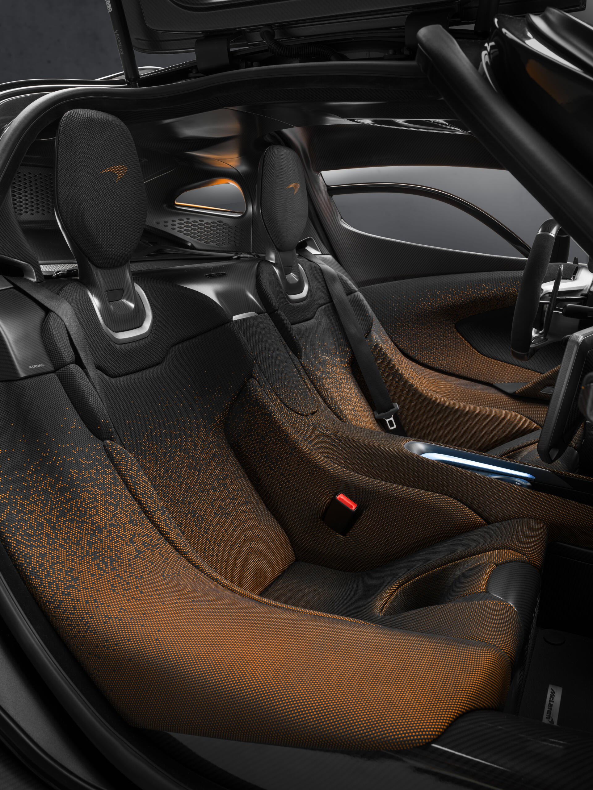Interior view of a McLaren W1, showcasing sleek, modern seating with distinctive materials and design elements, embodying the brand's high-performance ethos.