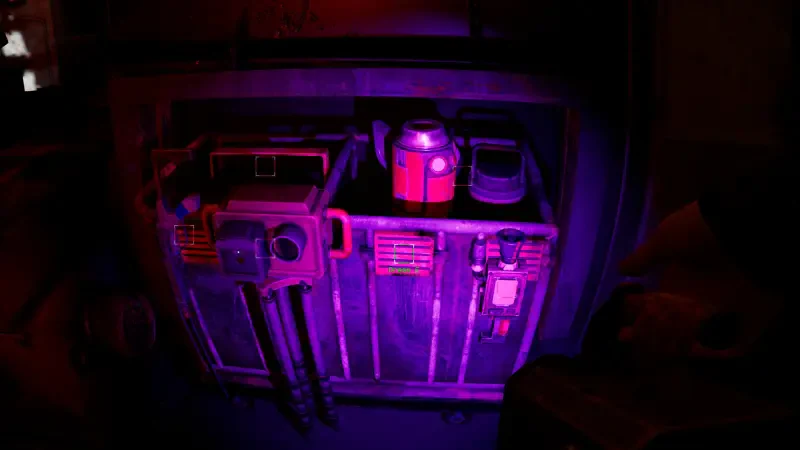 A close-up view of a sci-fi device featuring a red canister, as seen in the video game Zoochosis, illuminated by purple lighting.