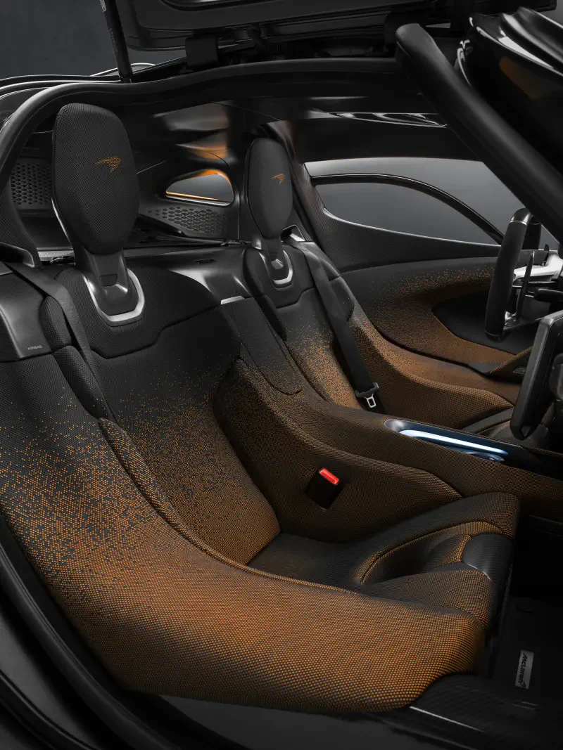 Interior view of a McLaren W1, showcasing sleek, modern seating with distinctive materials and design elements, embodying the brand's high-performance ethos.