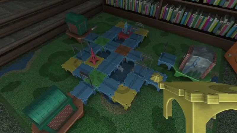 A colorful play mat featuring a game setup from Amanda the Adventurer 2, surrounded by toy structures and a bookshelf filled with books in the background.