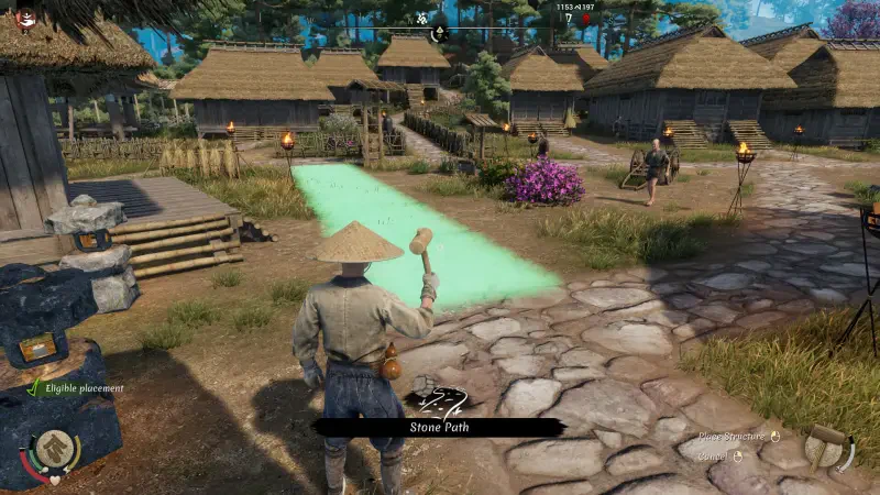 A character in traditional attire stands in a village setting in Sengoku Dynasty, with houses and greenery in the background, preparing to craft or interact with the environment.