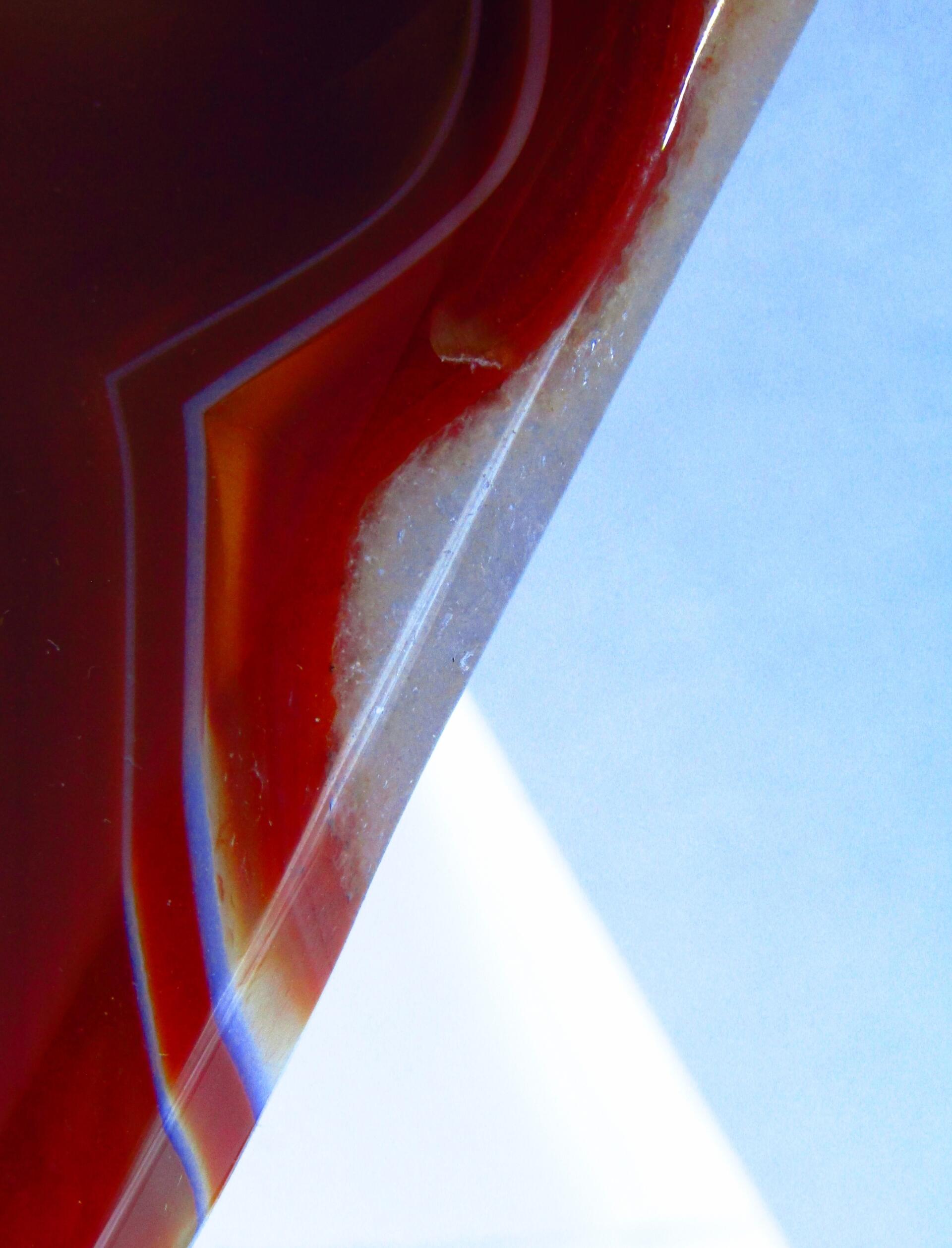 Polished red orange carnelian geode rock segment closeup. by Demasc1