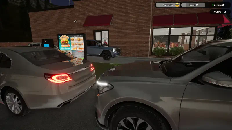 Cars line up in front of a fast food drive-thru as customers order from the menu in this engaging Fast Food Simulator scene. Bright lights illuminate the restaurant's exterior.