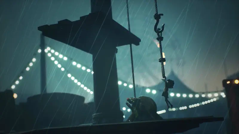 A dark, atmospheric scene from Little Nightmares III shows a figure suspended by a rope, with a backdrop of a rain-soaked environment and glowing lights in the distance.