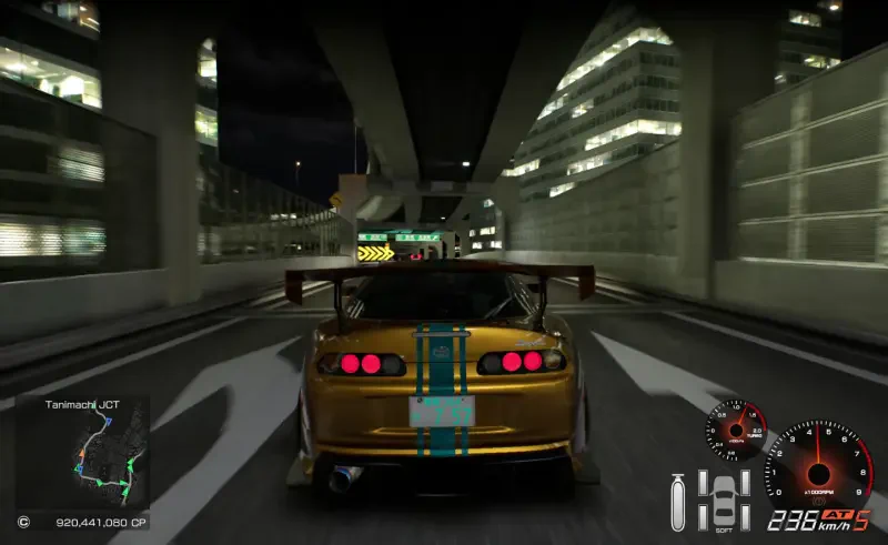 A vibrant night scene from Tokyo Xtreme Racer featuring a modified car with a prominent rear wing, racing through illuminated city streets with modern buildings in the background.