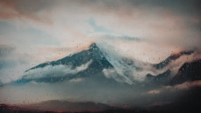  Window With Lots Of Rain Droplets Looking At A Mountain