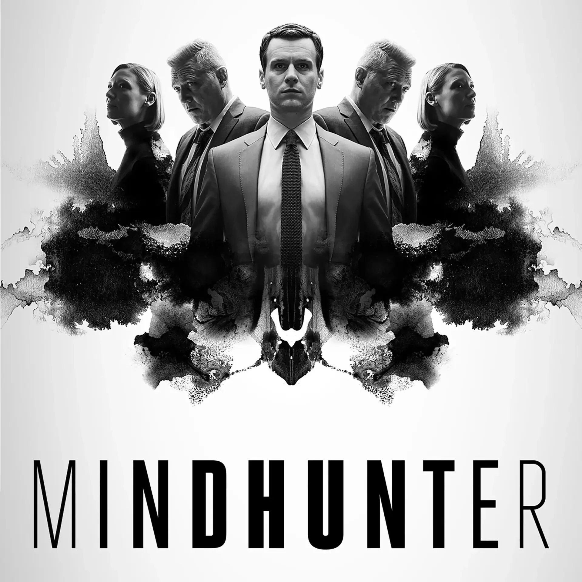 Black-and-white Mindhunter TV show poster: a stoic suited man centered, mirrored agents and Rorschach inkblot shapes behind him, the title MINDHUNTER at the bottom.