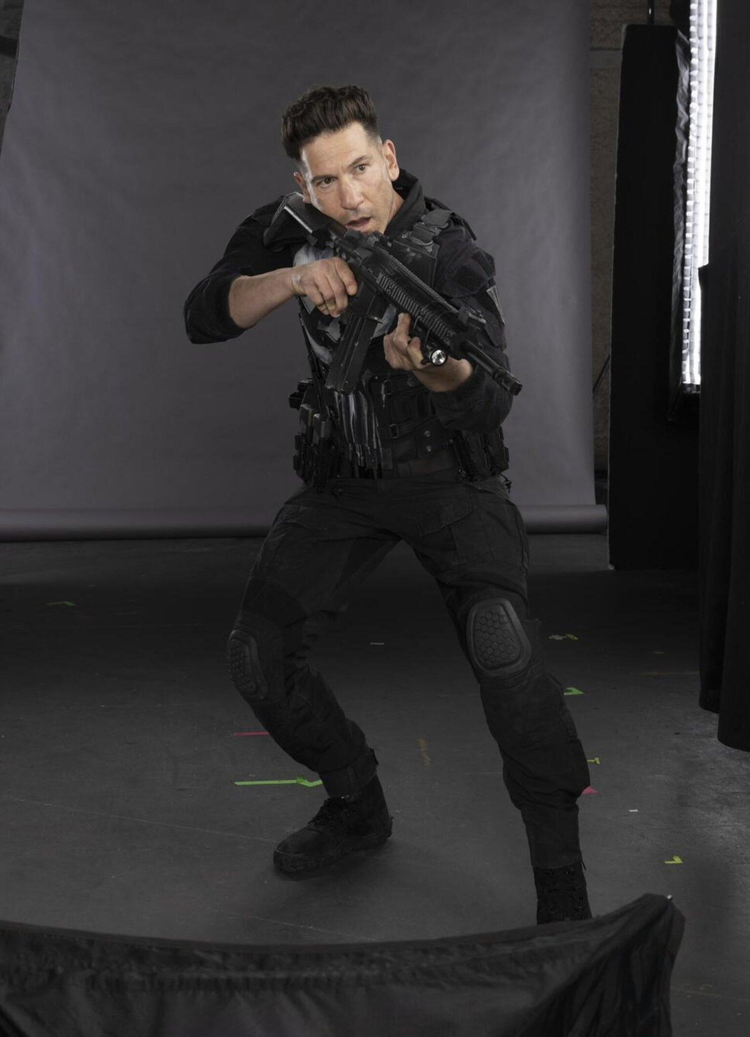 Person in black tactical gear aiming a rifle on a studio set, behind-the-scenes image for the TV show Daredevil: Born Again.