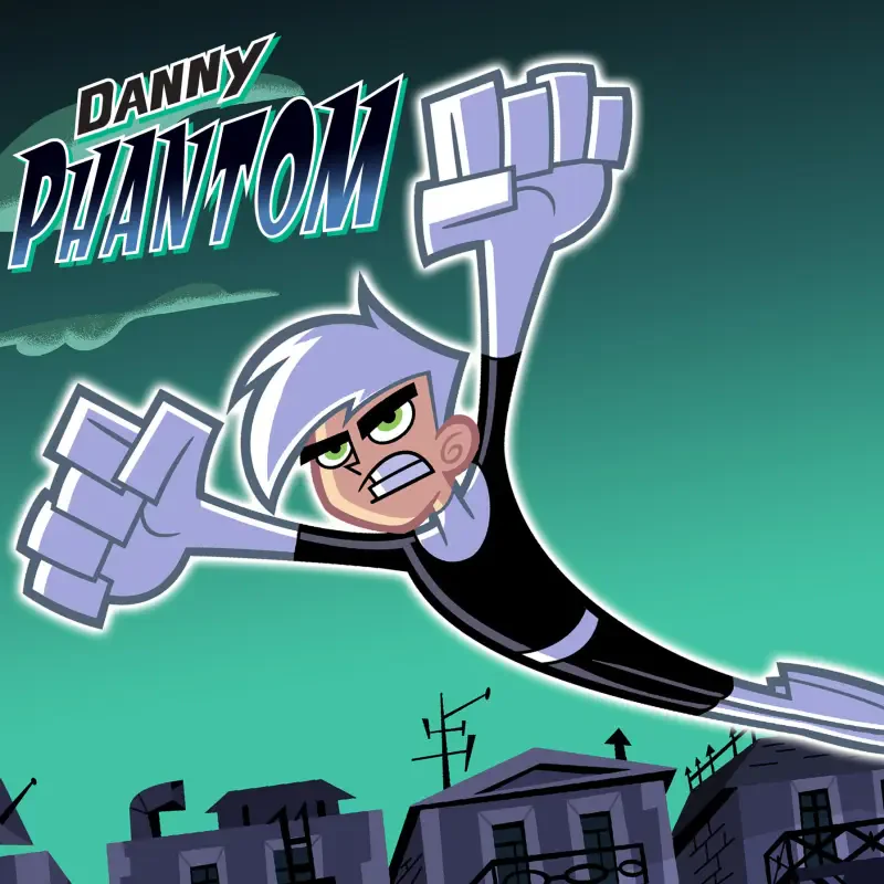 Danny Phantom flying above a silhouetted town at night, fists thrust forward, white hair and black suit, show logo in the corner.