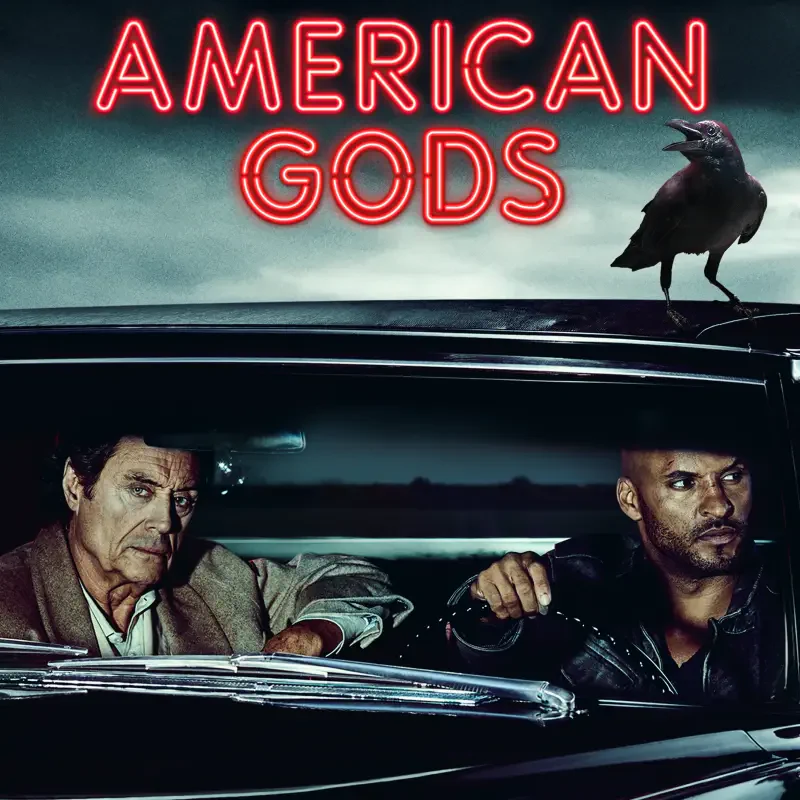 American Gods (TV show) promo: two men sit in a dark car while a raven perches on the roof beneath a neon title.