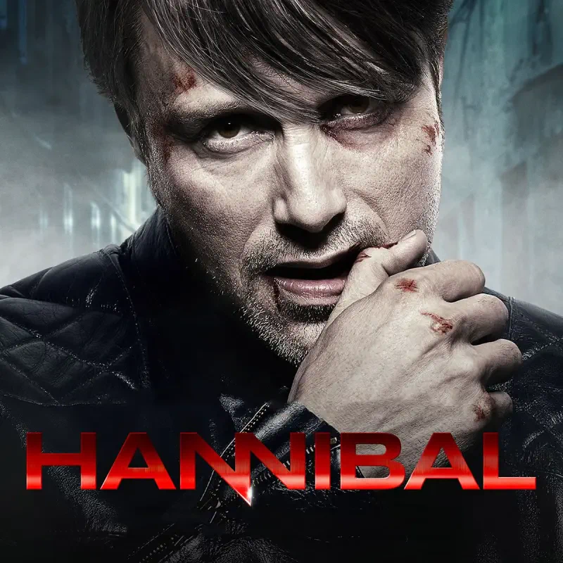 Close-up promo for the TV show Hannibal: intense man with dark hair, cuts and scratches, hand near mouth, red HANNIBAL title across the bottom.