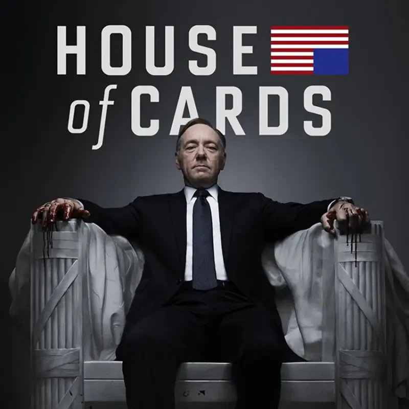 Promotional poster for the TV show House of Cards: a stern suited man sits in a throne-like chair, hands on armrests, beneath the show's title with a stylized American flag motif.
