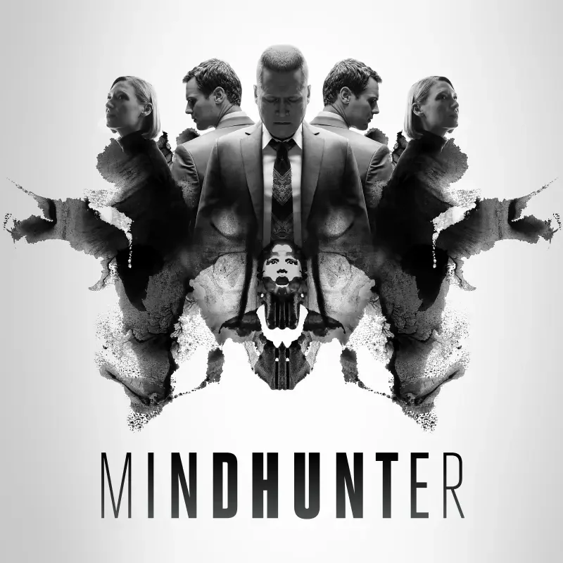 Black-and-white Mindhunter TV show poster: mirrored agents flank a Rorschach-style inkblot that forms a skull-like image, with the title Mindhunter beneath.