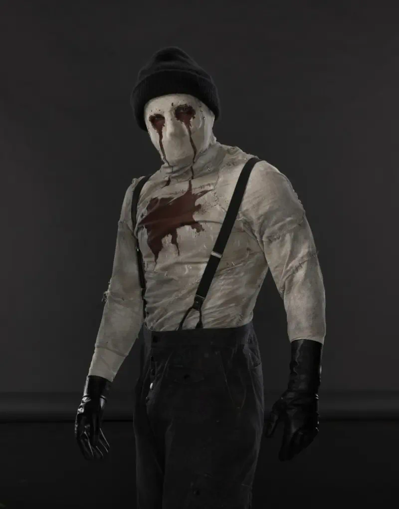 Bandaged masked figure with blood-streaked eyes and a chest stain, wearing suspenders, beanie and gloves — from Daredevil: Born Again (TV show).