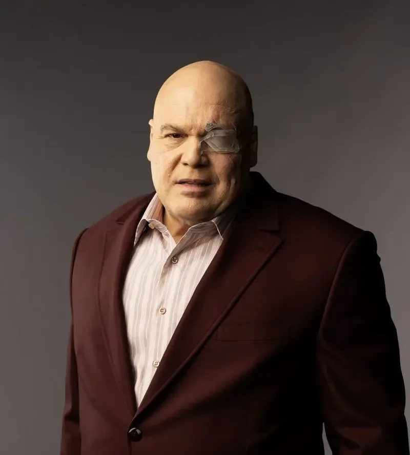 Bald, imposing Wilson Fisk (Kingpin) from Marvel's Echo TV show, wearing a dark burgundy suit and light shirt, staring ahead with a stern, authoritative expression.