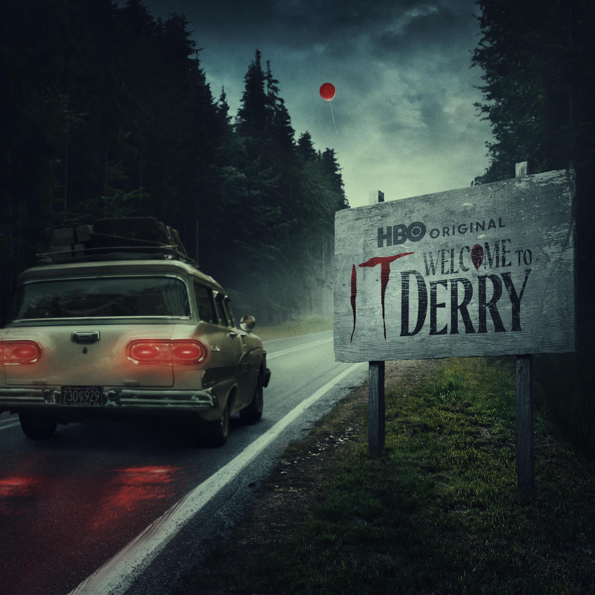 TV show poster It: Welcome to Derry — lone car on a rain-slick road through dark pines, roadside sign reading Welcome to Derry with a blood-dripping T.