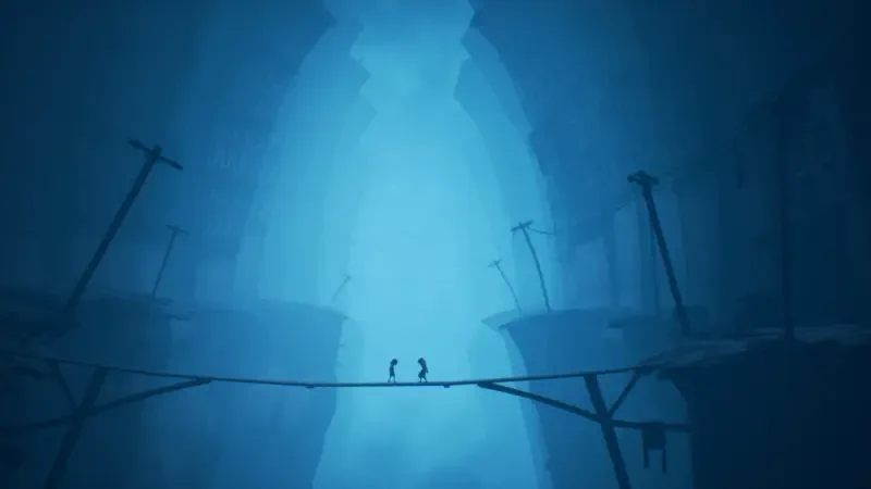 Two small silhouettes cross a fragile rope bridge over a vast blue-lit chasm with looming structures — a moody scene from Little Nightmares II.