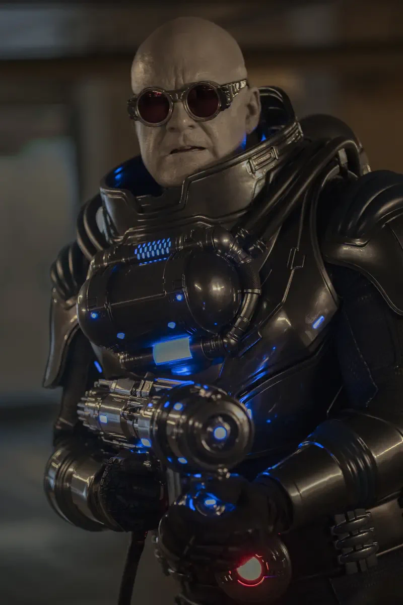 Mr. Freeze in a bulky armored cryogenic suit and goggles, aiming a freeze gun in a scene from the TV show Stuart Fails to Save the Universe (DC Comics).